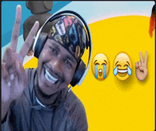 a man wearing headphones and a bandana is smiling and giving a peace sign .