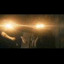 a person is standing in a dark room with a light shining on their face .