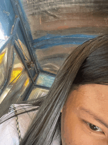 a close up of a woman 's face with a stained glass window in the background