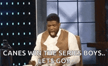 a man is sitting at a table with his mouth open and says canes win the series boys ... lets go !