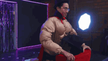 a man in a cowboy costume is holding a red hat