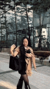 a woman wearing a scarf and gloves is walking down a sidewalk