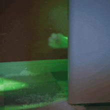 a stuffed animal is peeking out from behind a wall with a green light behind it