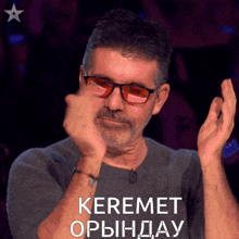 a man wearing glasses and a shirt that says keremet on it
