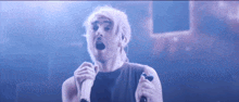 a man with white hair singing into a microphone