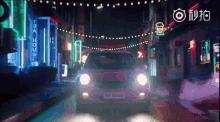 a pink car is driving down a street with a sign that says tea house