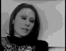 a black and white photo of a woman wearing a turtleneck sweater and a jacket .