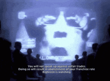 a group of people looking at a screen with the words " you will not speak up against unfair trades " on it