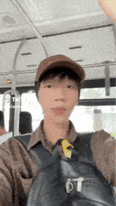 a man wearing a brown hat and a black backpack is taking a selfie on a bus .