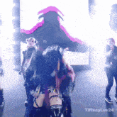 a group of people are dancing in front of a screen that says tiffanyluv24 on it