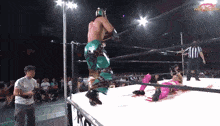 a wrestler is jumping over another wrestler in a wrestling ring