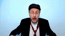 a man with glasses and a hat is wearing a tie
