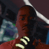 a man in a red shirt is holding a glowing object that says c