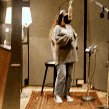 a woman wearing headphones is singing into a microphone in a recording studio
