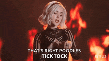 a woman is standing in front of a fire and says `` that 's right poodles , tick tock '' .