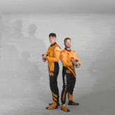 two men are dancing in front of a wall of confetti