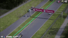 cars are racing on a race track with a banner that says total on it