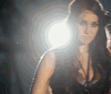 a woman is standing in front of a bright light