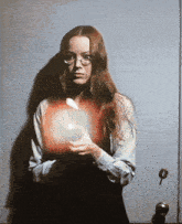 a woman wearing glasses is holding an apple in her hand