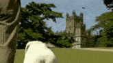a dog standing in front of a castle with a flag on top