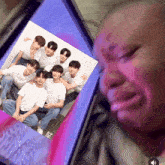 a picture of a group of young men is displayed on a phone screen