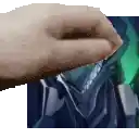 a close up of a person 's hand reaching out towards a green object .