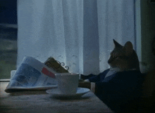 a cat sits at a table reading a newspaper and drinking a cup of coffee