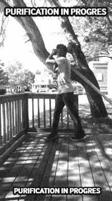 a black and white photo of a person standing under a tree with the words purification in progress above them
