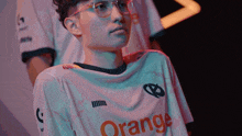 a man wearing glasses and a white shirt that says orange
