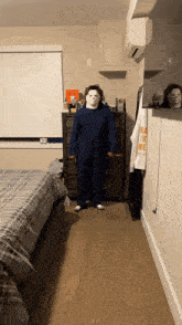 a person in a halloween costume is standing in a bedroom next to a dresser