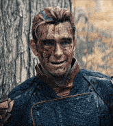 a man with blood on his face is smiling in front of a wooden wall