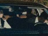 a man in a suit and tie stands next to a car