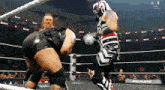 two wrestlers are fighting in a ring with raw written on the walls behind them
