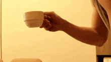 a man is drinking a cup of coffee in front of a mirror .