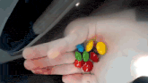 a person is holding a handful of m & m 's in their palm