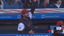 a man wearing a cleveland clinic jersey stands in a dugout