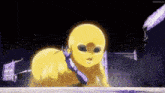 a yellow baby with a purple tie around its neck is crawling on the ground in front of a building .