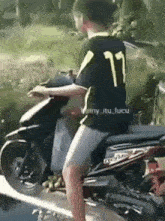 a young boy is riding a motorcycle with the number 77 on his shirt