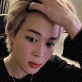 a close up of a person holding their head with their hand .