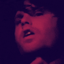 a close up of a person 's face with a purple background