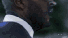 a close up of a man 's face with the starz logo visible
