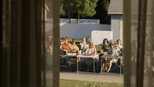 a group of people sitting at tables outside a house