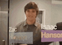 a man is standing in front of a glass wall with the names isaac and hansen on it