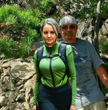 a man and a woman are posing for a picture and the woman is wearing a green shirt with the number 5 on it