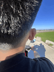 a person riding a scooter with their shadow on the side mirror