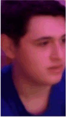 a close up of a man 's face wearing a blue shirt .