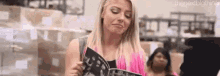 a woman is holding a magazine in a warehouse .