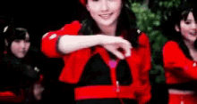 a woman in a red jacket is holding a glass of wine in her hand .