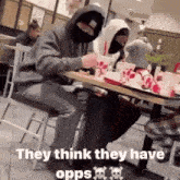 a man in a mask is sitting at a table in a restaurant eating a hamburger .