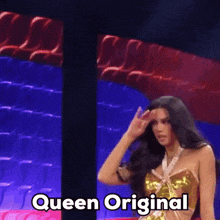 a woman is standing in front of a row of red seats and says queen original on the bottom